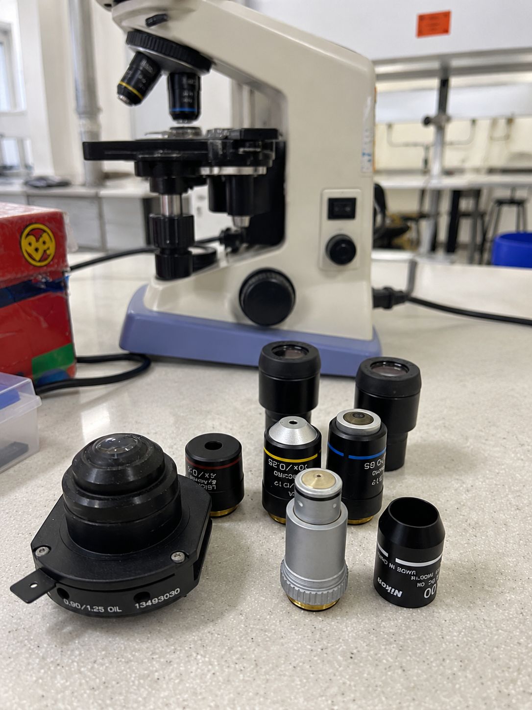 Microscope objectives, eyepieces and condenser laid out on a bench for servicing
